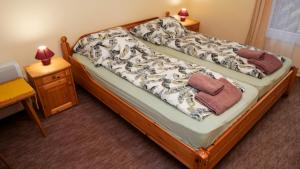 a bedroom with a bed and a table with a night stand at Tavasz apartman in Balatonfenyves