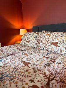a bed with a blanket with animals on it at Friar's Rest - Beauly Village in Beauly