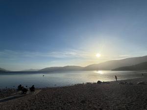 a group of people on a beach near the water at Friar's Rest - Beauly Village in Beauly