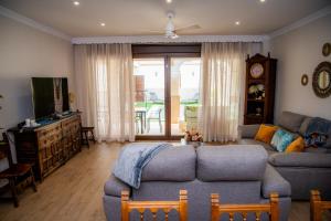 een woonkamer met een bank en een tv bij Casa Rural La Bodega de Cortés in Villagonzalo