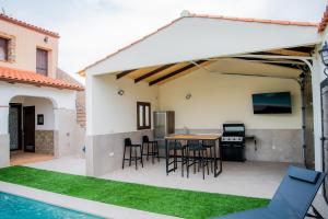 een terras met een tafel en stoelen en een zwembad bij Casa Rural La Bodega de Cortés in Villagonzalo