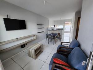 a living room with a couch and a tv on a wall at Casa 66 Completa Garagem 2ACs WIFI Juazeiro, Crato e Barbalha in Barbalha