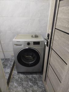 eine Waschmaschine in der Ecke eines Zimmers in der Unterkunft Дом in Taschkent