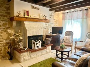 un salon avec une cheminée, un canapé et une chaise dans l'établissement Maison familiale Centre France, à Meunet-sur-Vatan