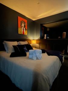 a large white bed with two towels on it at Chambre élégante avec terrasse in Souvigny