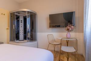 a bedroom with a bed and a table and chairs at Venus Suite - Romantic Private Spa - Centro Livorno in Livorno
