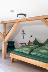 a bedroom with a wooden bed with green sheets at Kiefer -Ferienwohnung in Dötlingen mit Waldblick in Dötlingen