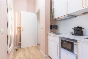 a kitchen with white cabinets and a refrigerator at Venus Suite - Romantic Private Spa - Centro Livorno in Livorno