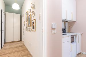 a kitchen with white cabinets and a white refrigerator at Venus Suite - Romantic Private Spa - Centro Livorno in Livorno +26 photos