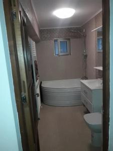 a bathroom with a tub and a toilet and a sink at Apartament Decebal- 2 dormitoare in Bistriţa
