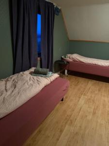una habitación con dos camas y una ventana en Sigridtunet - 4 bedroom Arctic experiences by the sea, with great opportunities to see the Northern lights dancing just for you!, en Tromsø