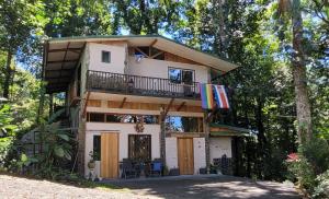 a house in the woods with a balcony at Nature Lovers Quepos in Quepos