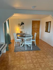 Un comedor con mesa y sillas en Sigridtunet - 4 bedroom Arctic experiences by the sea, with great opportunities to see the Northern lights dancing just for you!, en Tromsø 15 fotos más
