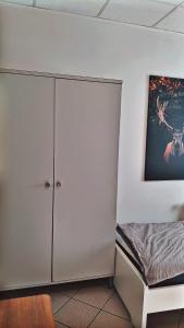 a bedroom with a bed and a white cabinet at Tyson in Gelnhausen