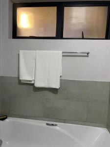 Un baño con dos toallas blancas colgadas en un toallero. en Modern Apartment in Centurion, en Centurion
