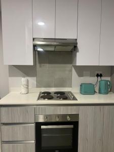 cocina con fogones y armarios blancos en Modern Apartment in Centurion, en Centurion