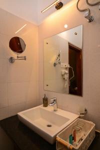 a bathroom with a sink and a mirror at Arara Mhas Hotel in Cherrapunji