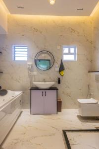 a white bathroom with a sink and a mirror at Zephyr Luxury 2BHK With Private Jacuzzi Nr Anjuna in Siolim
