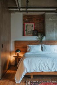 ein Schlafzimmer mit einem großen Bett mit einem hölzernen Kopfteil in der Unterkunft Hotel dieztreintayseis in Medellín