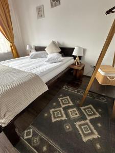 a bedroom with a bed and a rug on the floor at Casa meșterului in Sohodol