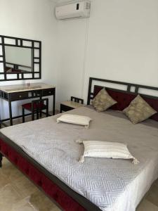 a bed in a room with a desk and a bed sidx sidx sidx at F3 et Piscine Port Yasmine Hammamet in Yasmine