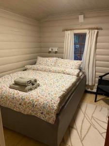 a bed with towels on it in a bedroom at Skogshytte in Holmøyane