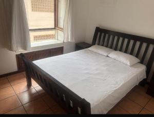 ポルト・セグロにあるCondominio Villa Aurora, 150m da Praia de Taperapuam!の窓付きのベッドルームに座ってベッド1台