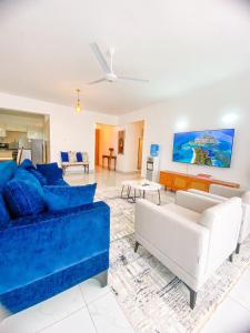 ein Wohnzimmer mit einem blauen Sofa und einem Tisch in der Unterkunft Majestic Apex Residence in Bamburi