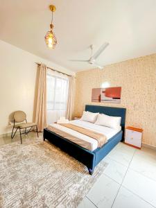 ein Schlafzimmer mit einem Bett und einem Stuhl darin in der Unterkunft Majestic Apex Residence in Bamburi