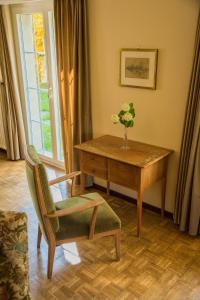 une table et une chaise avec un vase de fleurs dans l'établissement Large Home in Country near Zurich, à Othmarsingen