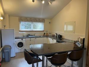 een keuken met een tafel, een wasmachine en een droger bij Hopeman Cottage in Hopeman