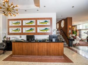 a lobby with a reception desk and a chandelier at Hotel Croydon in Miami Beach