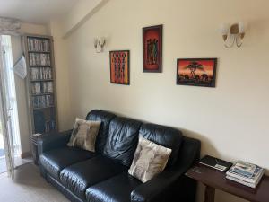 een zwarte leren bank in de woonkamer bij Hopeman Cottage in Hopeman
