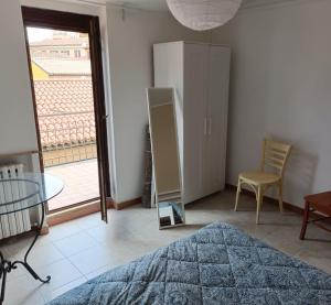 a bedroom with a bed and a table and a window at La Gatta sui Tetti in Osimo