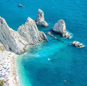 a group of people on a beach near the water at La Gatta sui Tetti in Osimo