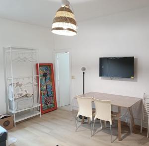 a dining room with a table and chairs and a tv at La Gatta sui Tetti in Osimo +3 photos