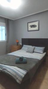 a bedroom with a large bed with a green pillow at Parque De Las Naciones Dragon con garaje ! in Torrevieja