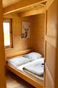 eine kleine Hütte mit einem Bett in einem Zimmer in der Unterkunft Domki pod Halą Krupową in Ohłypów + 84 Fotos