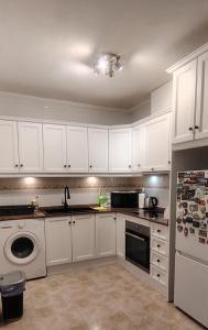 a kitchen with white cabinets and a sink and a dishwasher at Parque De Las Naciones Dragon con garaje ! in Torrevieja +6 photos