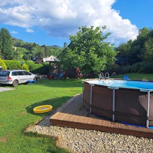 a swimming pool with a frisbee next to a yard at Horská chaloupka Bělá pod Pradědem in Bělá pod Pradědem