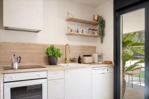 a kitchen with white cabinets and a sink at Chez Marie in La Muela