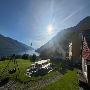 Una mesa de picnic en un patio con vista a un lago. en Jåstad Gjestetun, en Jåstad