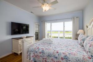een slaapkamer met een bed, een tv en een raam bij 325 Ocean Point in Fripp Island