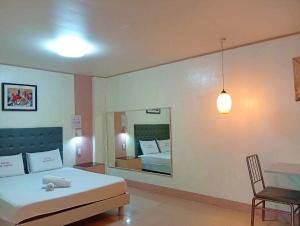 a bedroom with a large bed and a mirror at Wjv Inn Time Square in Mandaue City