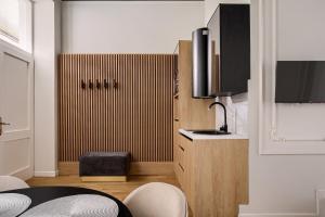 a kitchen with a wooden cabinet with a sink and a stool at Bulevard Suite in Arad
