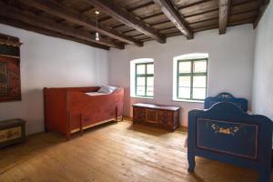 Habitación con 2 camas, mesa y ventanas. en Viscri 9 en Viscri