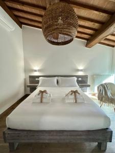 a bedroom with a large white bed with a chandelier at Under The Tuscan Sun in Arezzo