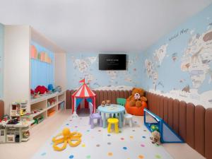 a childs room with a play area with a crib and toys at Mercure Bangkok Sukhumvit 11 in Bangkok