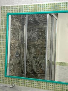 a mirror in a bathroom with a tiled wall at Minerva in Viareggio