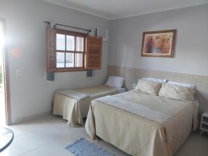 un dormitorio con una cama y una ventana en Hospedagem Central Eu Amo Piri, en Pirenópolis